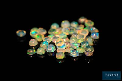 un tas de perles d'oplite blanches sur une surface noire