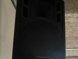 a black speaker that is hanging from the ceiling