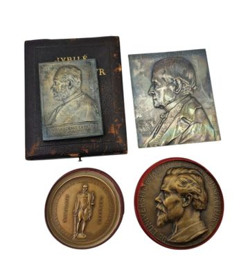 three medals and a book on a white background