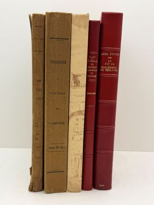 trois livres sont alignés les uns sur les autres sur une surface blanche
