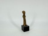 statue d'une femme debout sur un socle noir, sur fond blanc