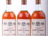 trois bouteilles de vin posées les unes à côté des autres sur une surface blanche
