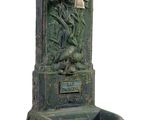 a green water fountain with a statue on it