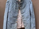 une vieille veste bleue suspendue à un cintre accroché au mur