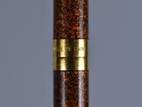 the pen is made of wood and has a gold trim