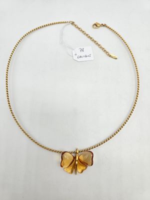 un collier en or avec un pendentif en forme de papillon sur une chaîne