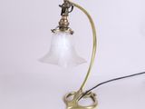 une lampe de table ancienne en laiton avec un abat-jour en verre, sur fond blanc