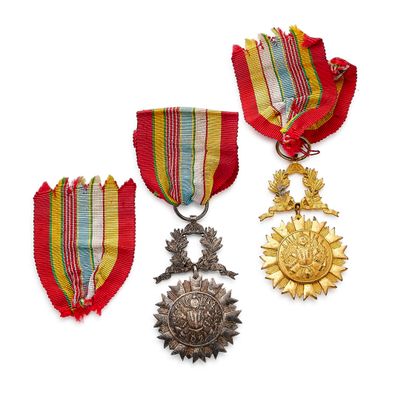 three medals and a medal are sitting on a white surface