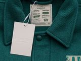a label on a green shirt with a white tag on it