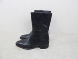 black leather cowboy boots with a black heel on a white surface