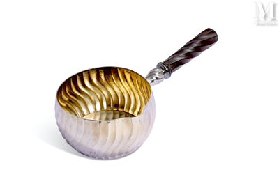 une coupe en argent et en or, dotée d'une poignée en bois, posée sur un fond blanc