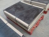 Plusieurs blocs de granit noir sont empilés sur une palette