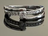 a close up of a diamond ring on a reflective surface