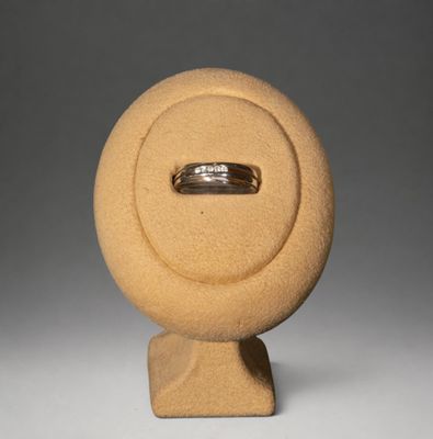 un anneau posé au sommet d'une sculpture posée sur un socle