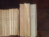 several old books are lined up on a shelf in a library