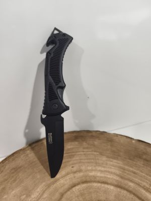 a close up of a knife on top of a piece of wood