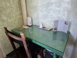 a green table with two chairs and a mirror on the wall