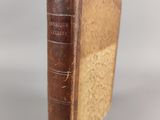 an old book sitting on top of a table next to a white wall