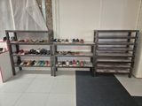 many pairs of shoes sitting on the shelves in the room