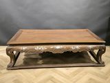 a wooden coffee table with ornate carvings on top of it