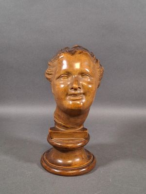 carved wooden bust of a young man on a pedestal