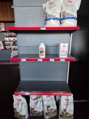 many bags of dog food on the shelves in the store