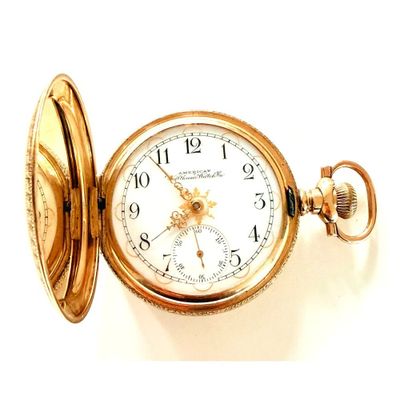 une montre de poche en or posée sur une surface blanche
