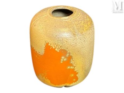 un vase orange posé sur une surface blanche