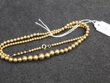 un collier de perles dorées sur un fond noir