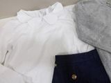 a white shirt and a blue skirt on a bed
