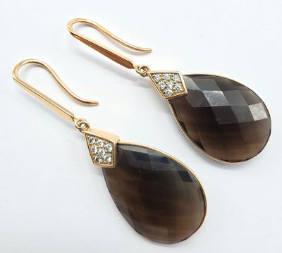 une paire de boucles d'oreilles noires et dorées ornées de cristaux