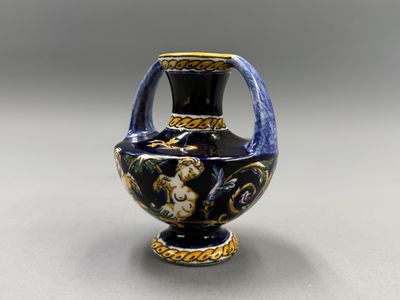 un vase bleu et or posé sur une table