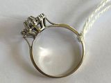 une bague en argent ornée de trois diamants, sur un fond blanc