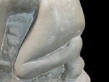 a statue of a woman sitting on a rock
