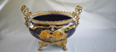 un vase bleu et or posé sur un socle