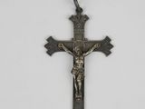 une croix métallique avec un crucifix sur fond blanc