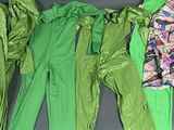 Plusieurs vêtements de différentes couleurs sont alignés sur une surface noire.