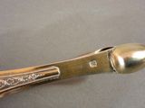 a silver spoon with a gold handle on a table