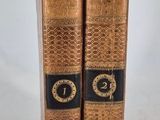 two old books that are sitting on a table