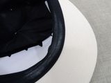a black and white hat on a table with a black umbrella