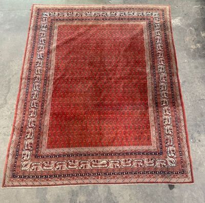 a red and black rug on a concrete floor