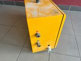 a yellow fire hydrant sitting on the floor next to a red wall