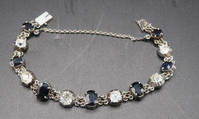 bracelet en argent orné de perles de verre noires et transparentes, montées sur une chaîne en argent