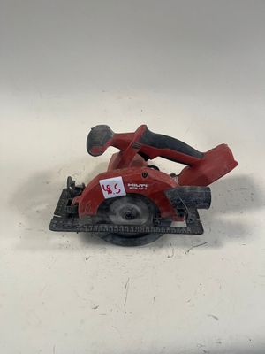 une photo d'une scie circulaire rouge posée sur une surface blanche