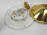 a close up of a gold and white light fixture on a white surface