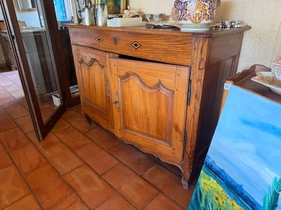 une armoire en bois ornée d'un tableau, dans une pièce