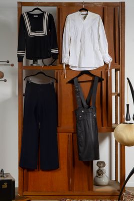 un placard contenant des vêtements et une chaise dans la pièce
