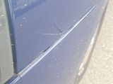 a blue car that has a hole in the side of it