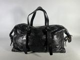 black leather duffel bag sitting on a white surface
