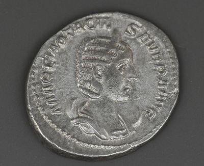 gros plan d'une pièce de monnaie sur laquelle figure une tête de femme